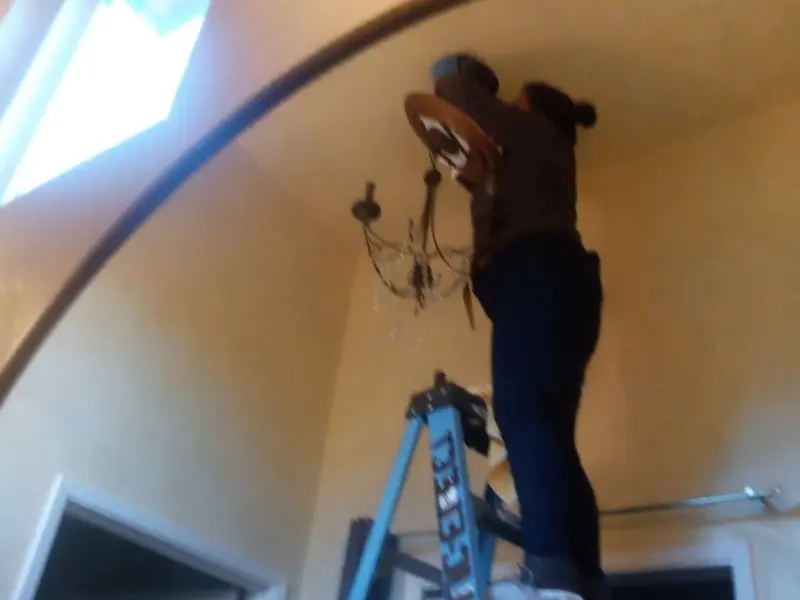 Electrician installing a chandelier in a Goleta residence